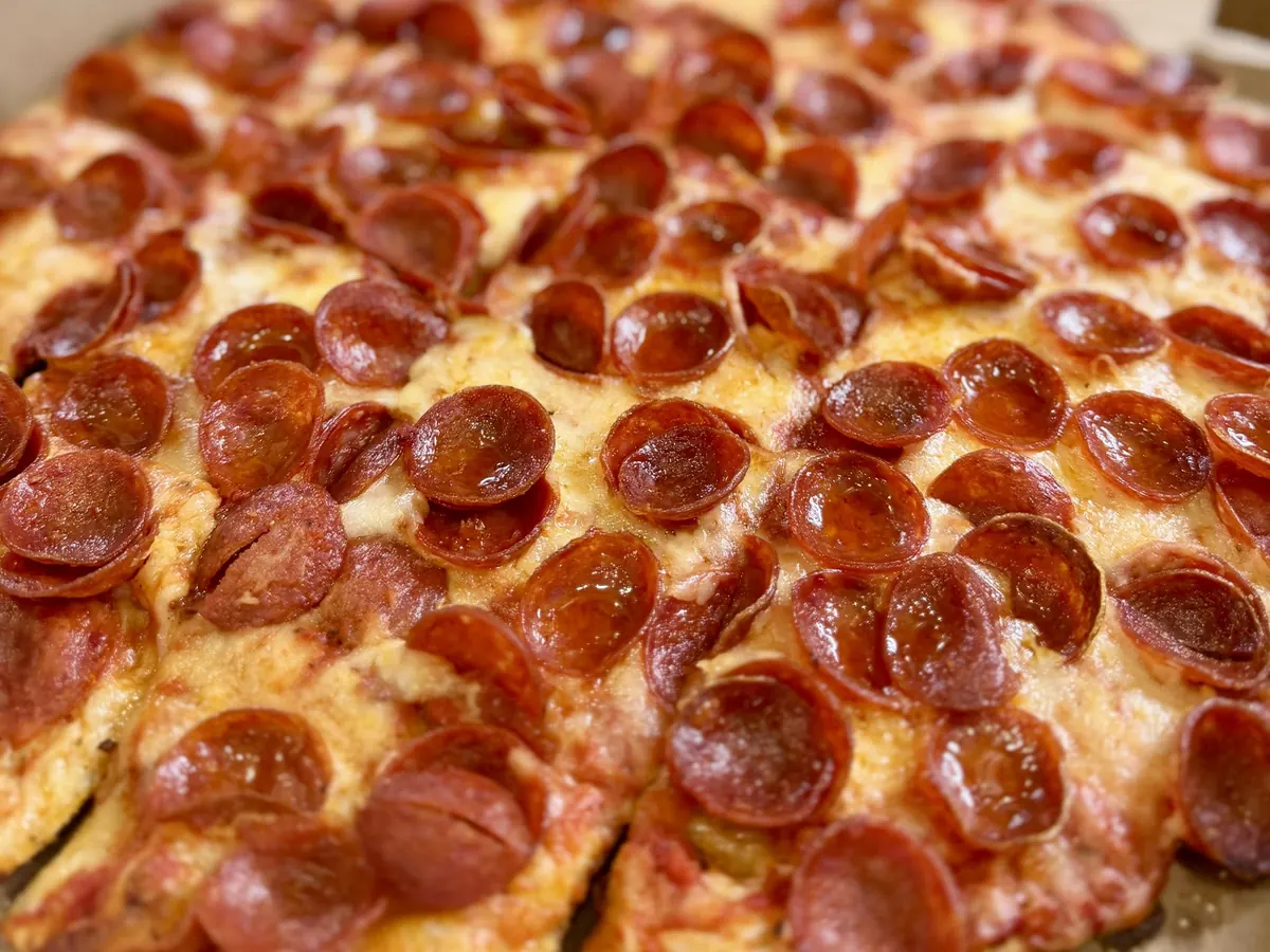 Close-up of crispy cup-and-char pepperoni on a Peppy's tavern-style pizza